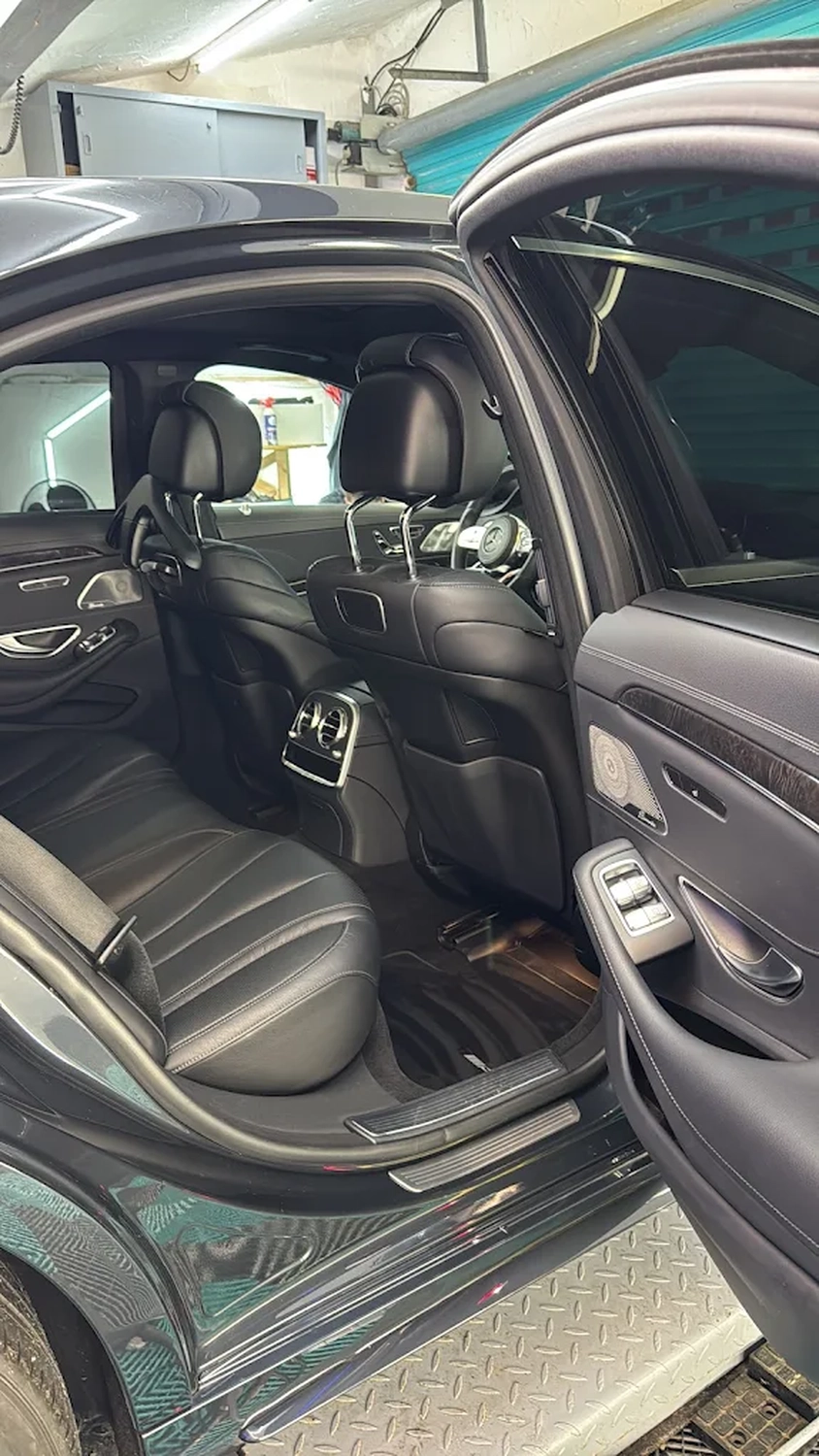 Simons Garage - Fahrzeugaufbereitung - Luxuriöser Innenraum eines modernen Autos mit schwarzen Ledersitzen hinten und Klimaanlage.