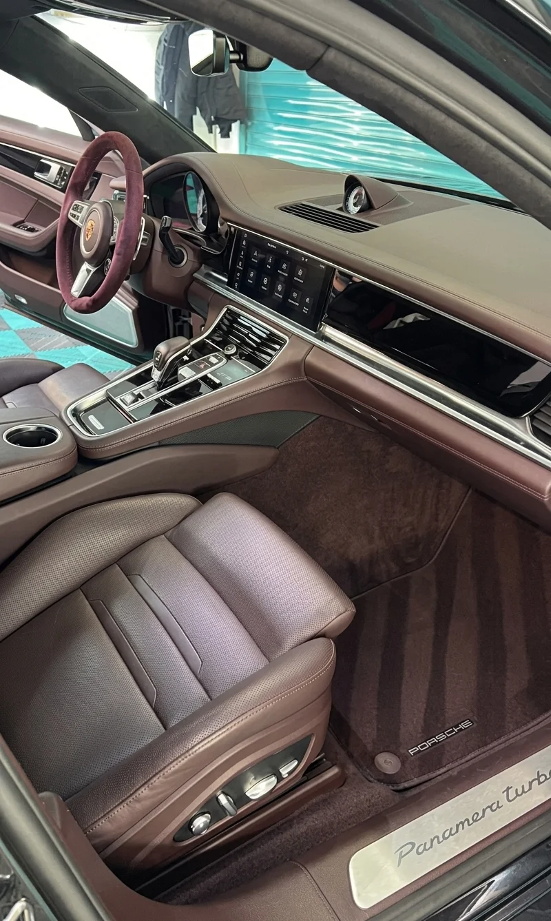 Simons Garage - Fahrzeugaufbereitung - Der luxuriöse Innenraum eines modernen Autos mit hellbraunem und braunem Leder, inklusive Beifahrersitz, Mittelkonsole und Armaturenbrett.