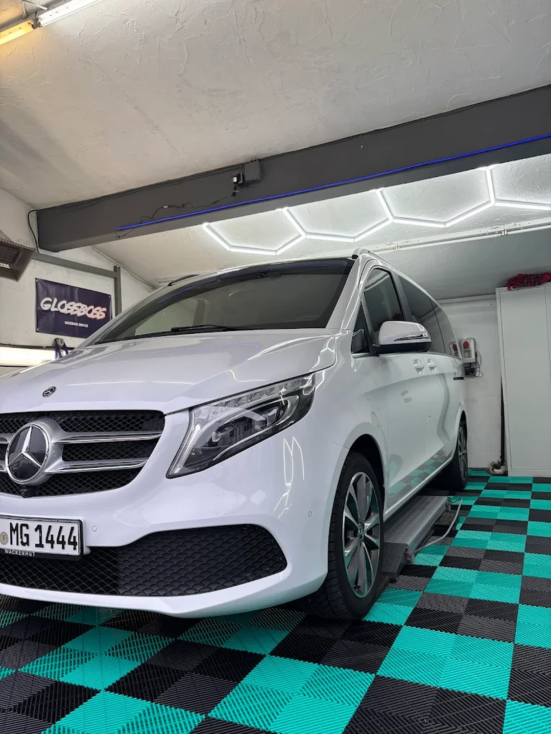 Simons Garage - Fahrzeugaufbereitung - Weißer Mercedes-Benz Transporter in einer hellen, modernen Aufbereitungswerkstatt.