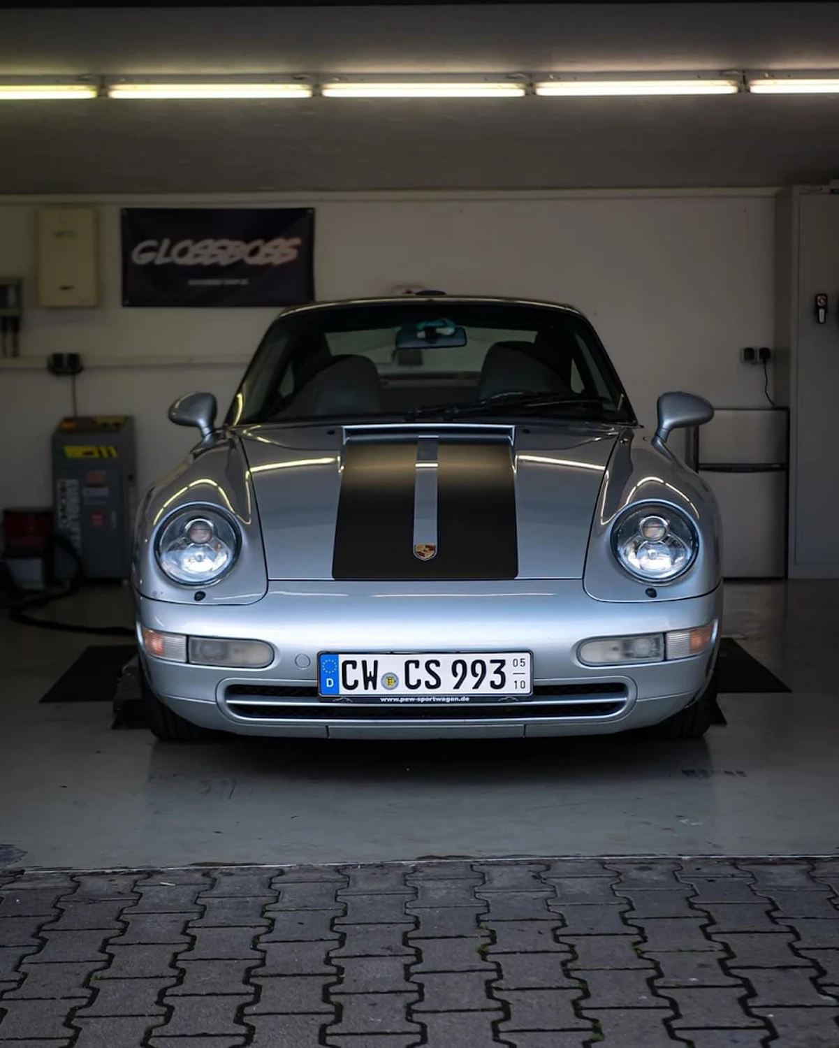 Simons Garage - Fahrzeugaufbereitung - Frontansicht eines klassischen silbernen Porsche 911 in einer Garage.